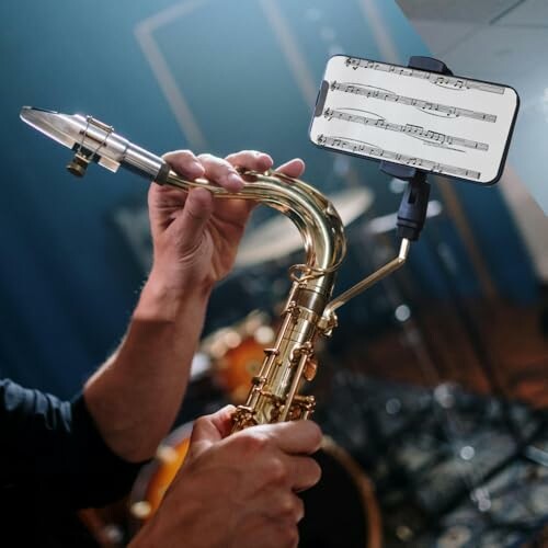 Person playing saxophone with digital sheet music on phone.